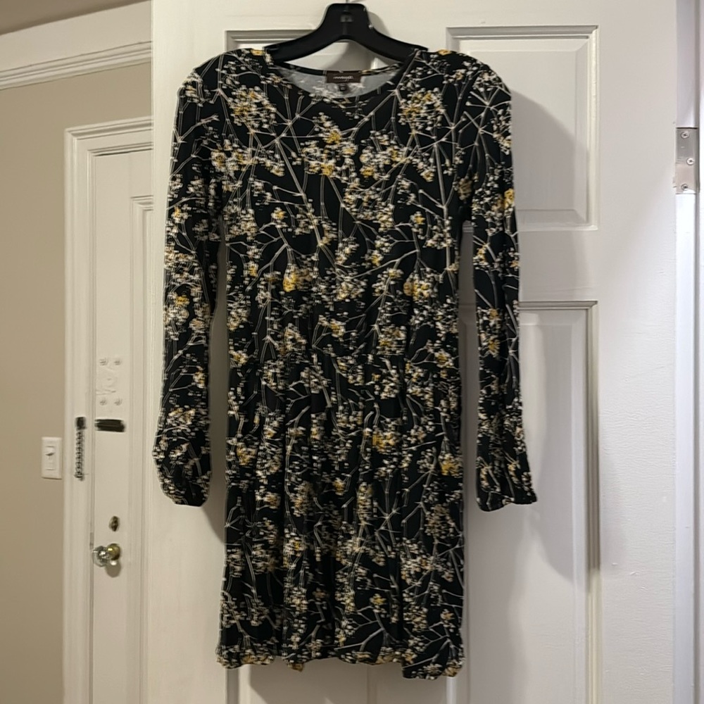 A yellow, white, black dress, that is long sleeve and lightly worn